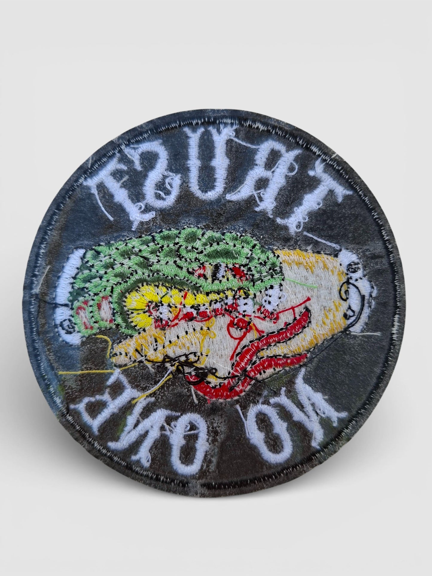 Parte trasera parche circular con frase "Trust No One" y diseño de mano mordida por una serpiente estilo Old School.