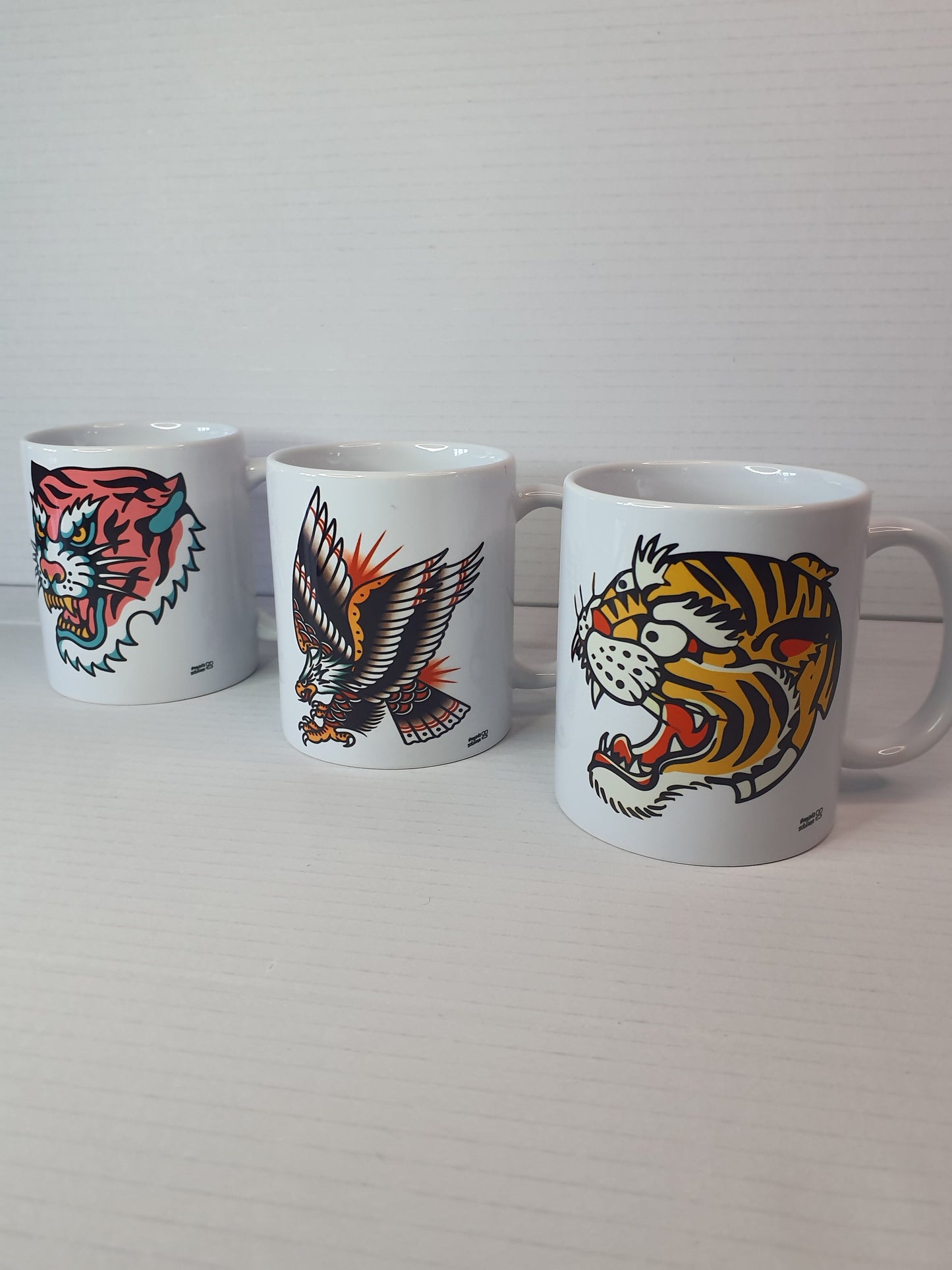 Tazas old school con diseño de agúila y tigres estilo tradicional retro.