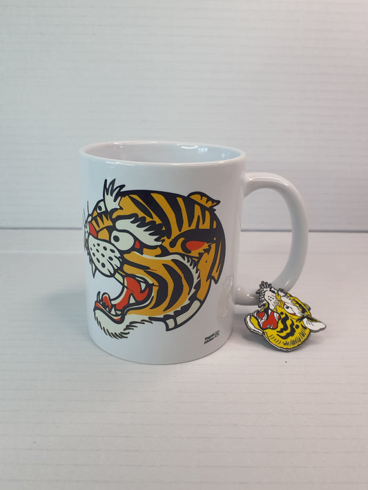"Pack de taza y pin con diseño de tigre estilo old school, inspirado en tatuajes tradicionales, en colores vibrantes y trazos perfectos."
