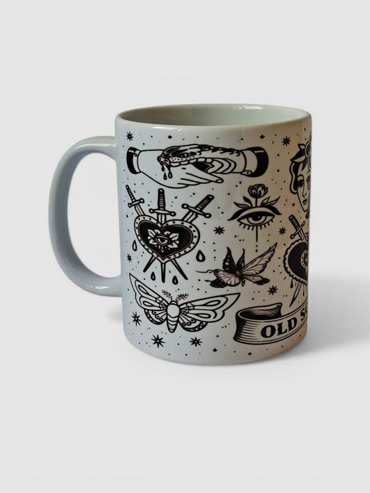 Taza old school tattoo blanco y negro con corazón atravesado por dagas y diseño tradicional