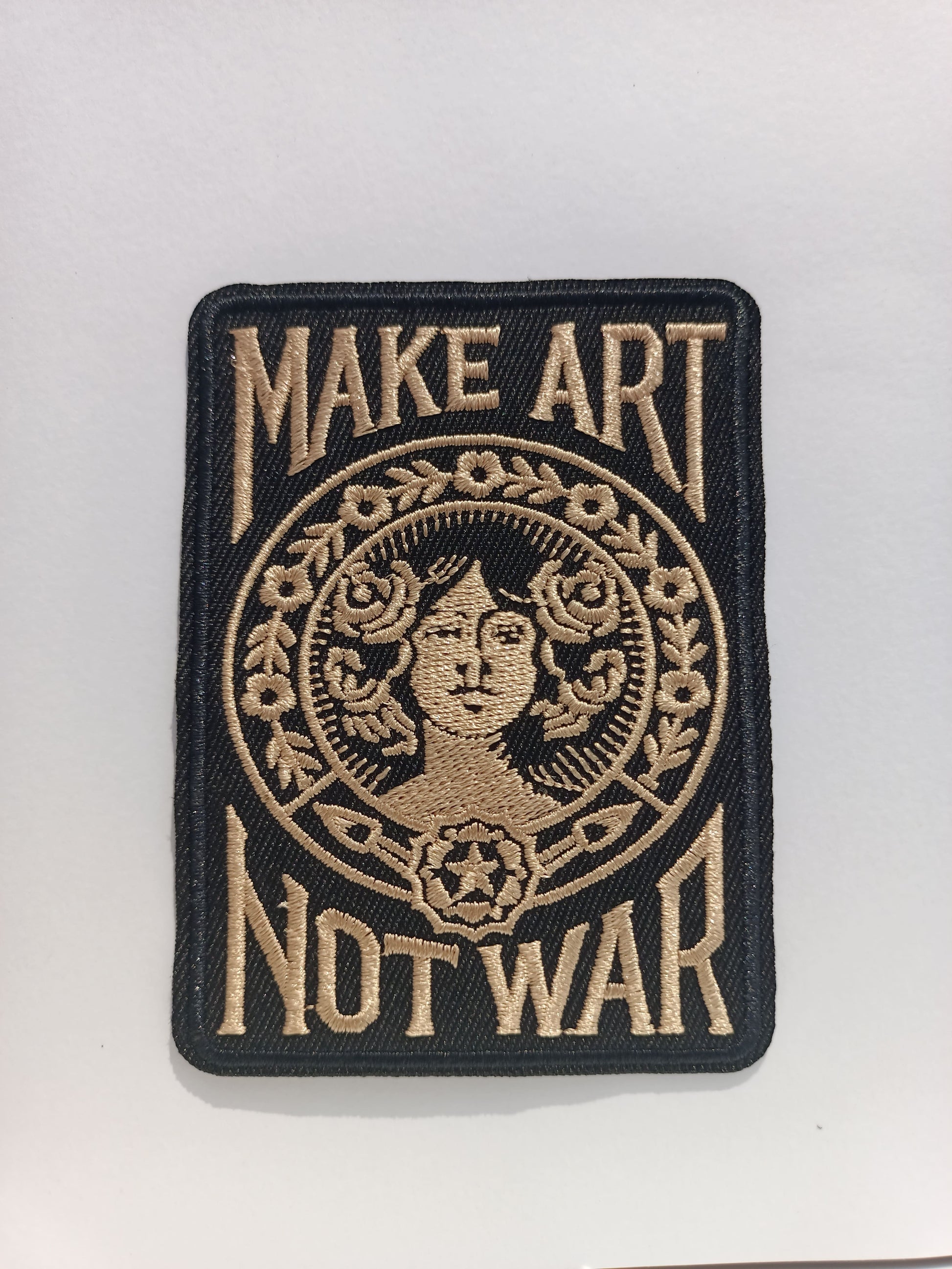 Parche Tattoo rectangular en negro con la icónica frase Make Art Not War y diseño gráfico clásico bordado.
