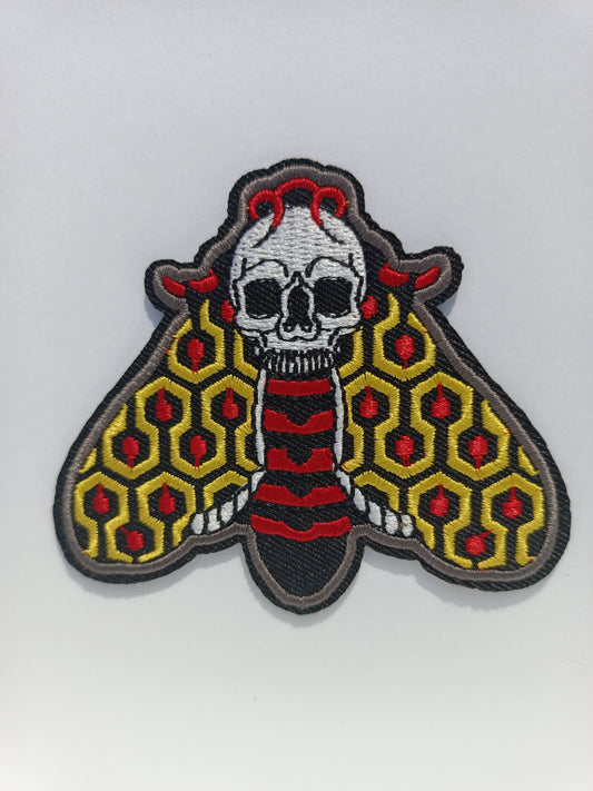 Parche bordado de polilla en colores vibrantes, inspirado en el estilo de tatuaje tradicional old school.
