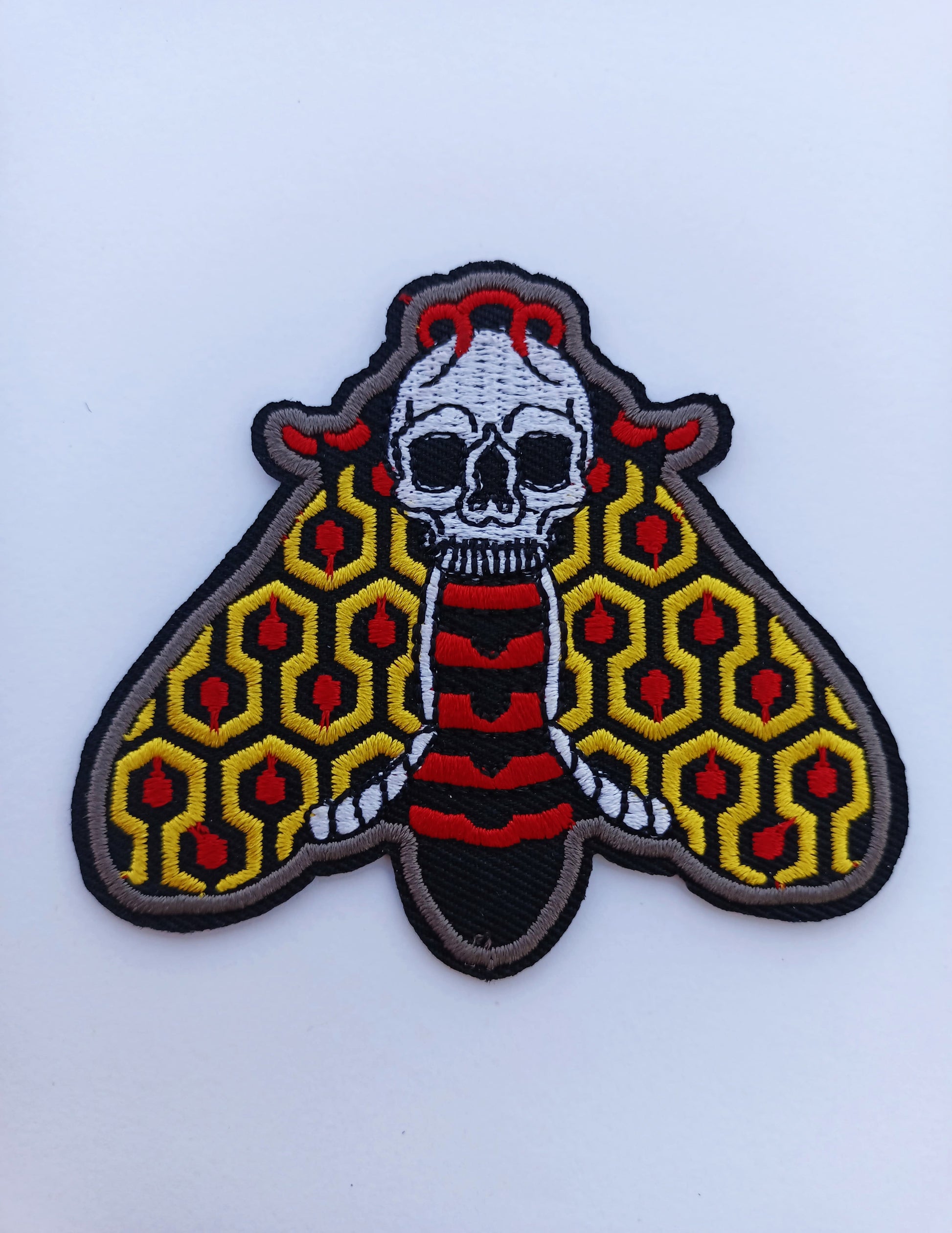 Parche bordado de polilla en colores vibrantes, inspirado en el estilo de tatuaje tradicional old school.