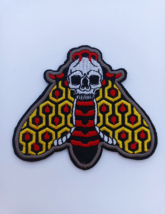 Parche bordado de polilla en colores vibrantes, inspirado en el estilo de tatuaje tradicional old school.