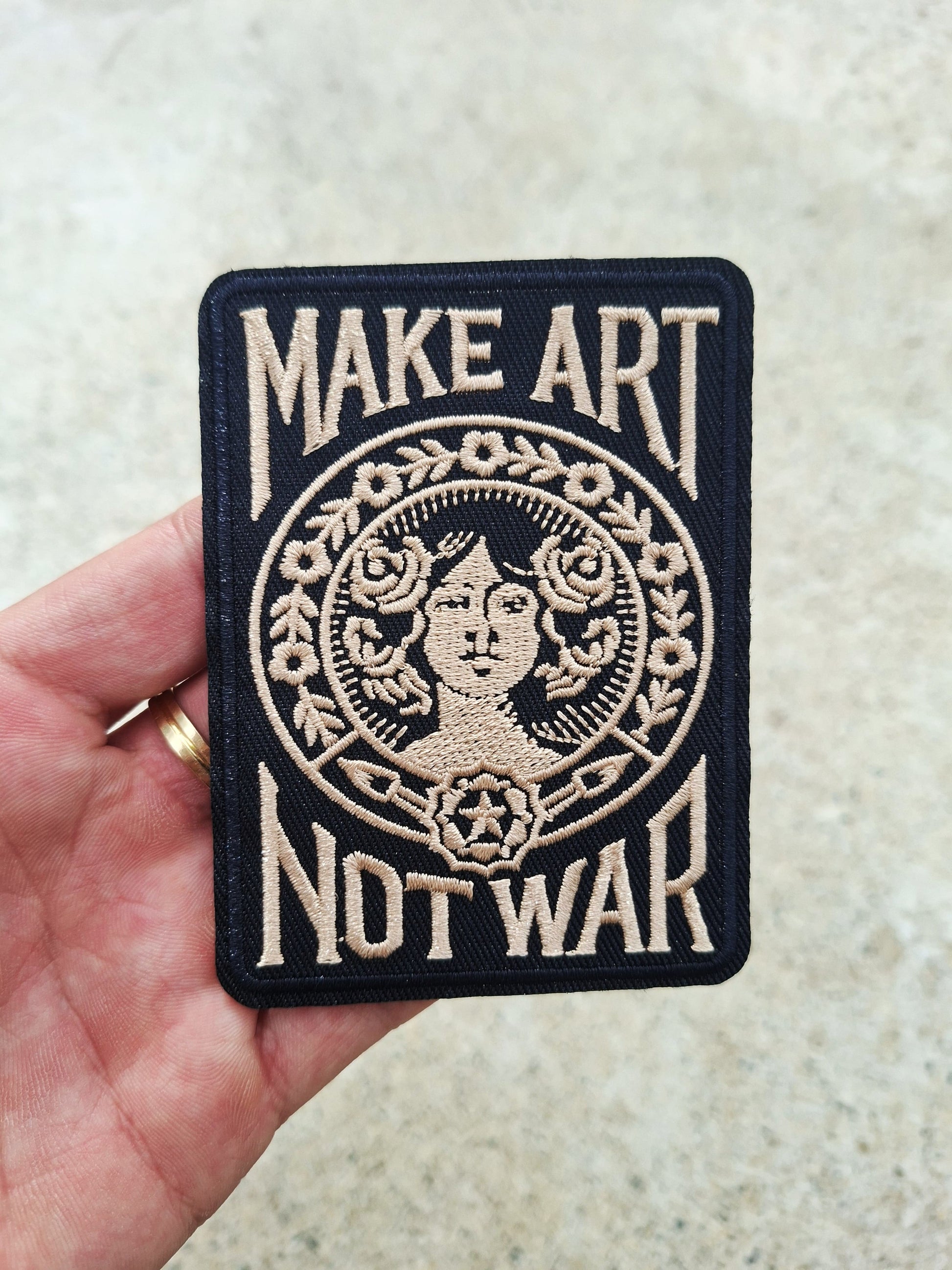 Parche Tattoo rectangular en negro con la icónica frase Make Art Not War y diseño gráfico clásico bordado.