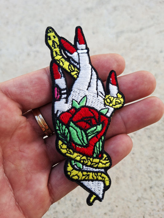 Parche exclusivo estilo tatuaje tradicional, con diseño de una mano y una serpiente entrelazándose entre si.