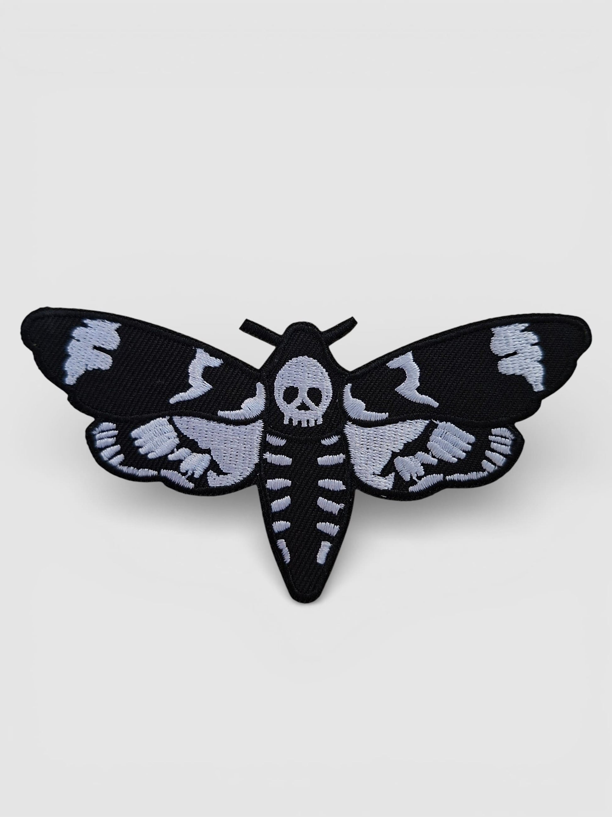 Parche bordado en blanco y negro de mariposa estilo tattoo old school ideal para chaquetas o accesorios.