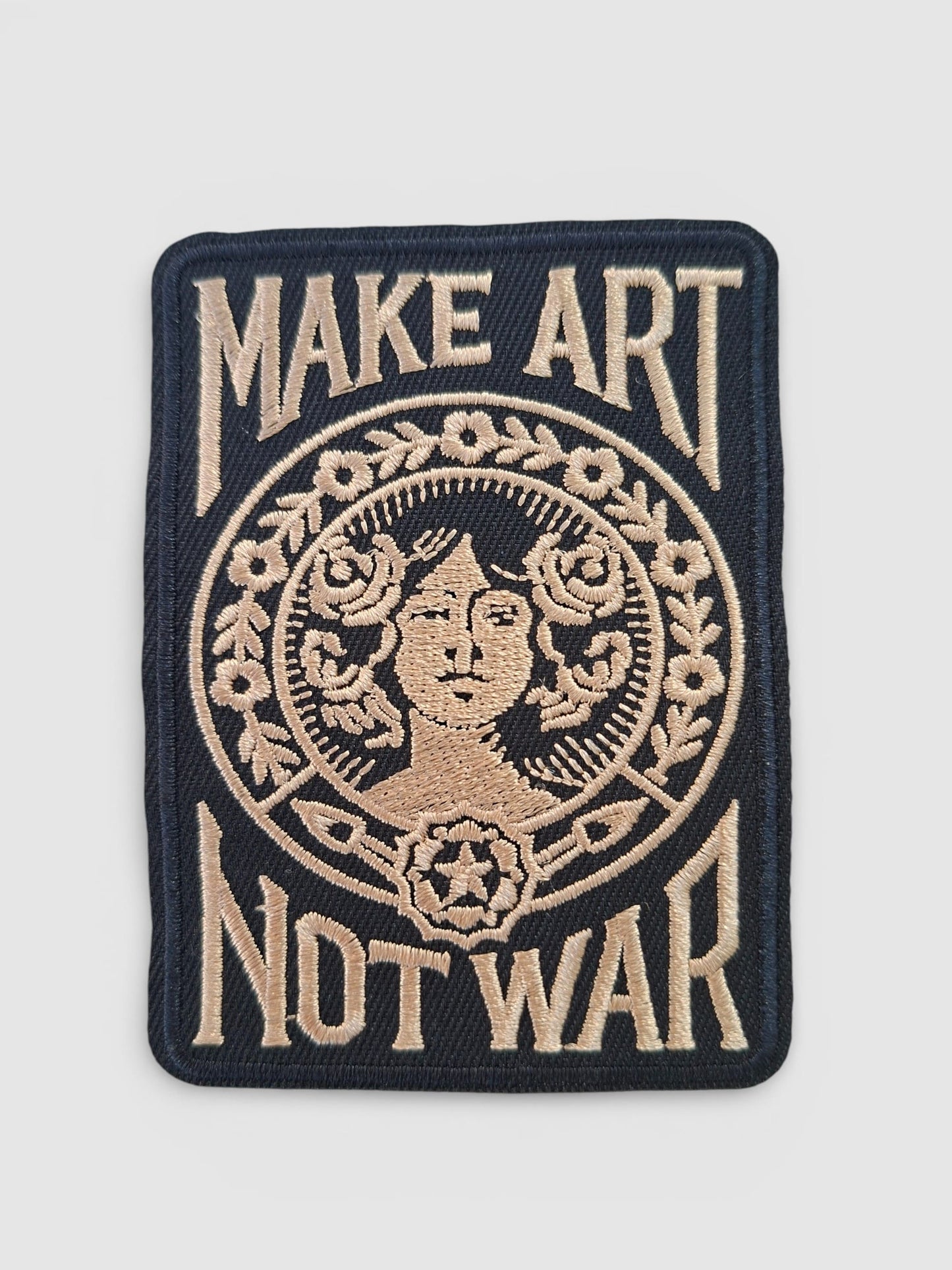 Parche make art not war en negro y dorado, estilo tattoo vintage.
