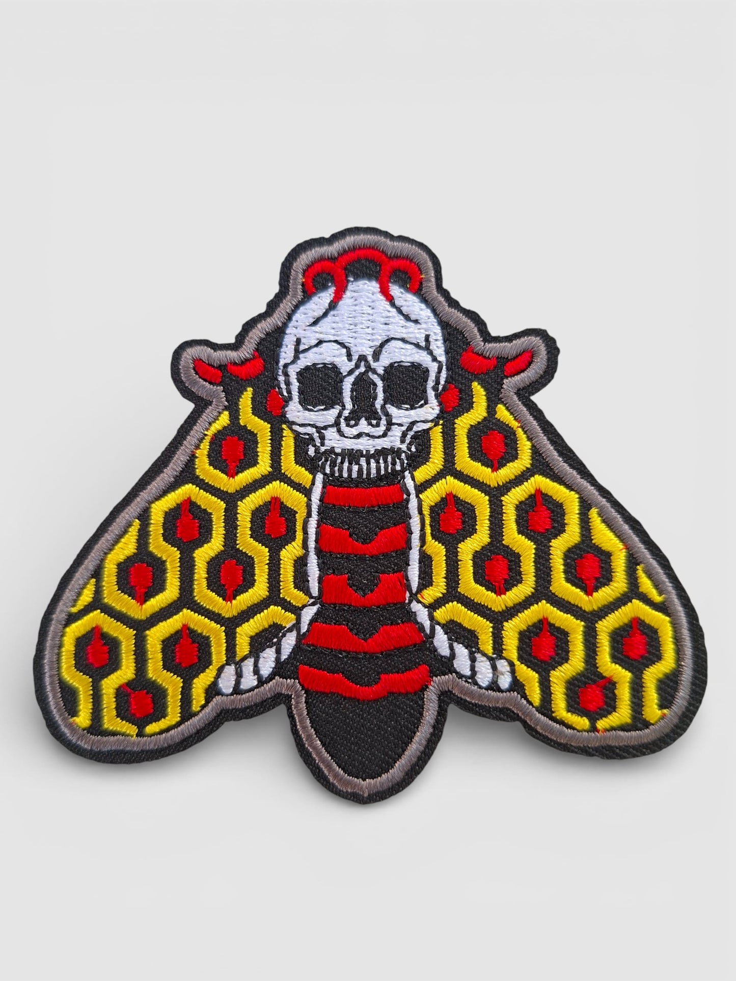 Parche premium bordado de polilla en colores vibrantes, inspirado en el estilo de tatuaje tradicional old school.