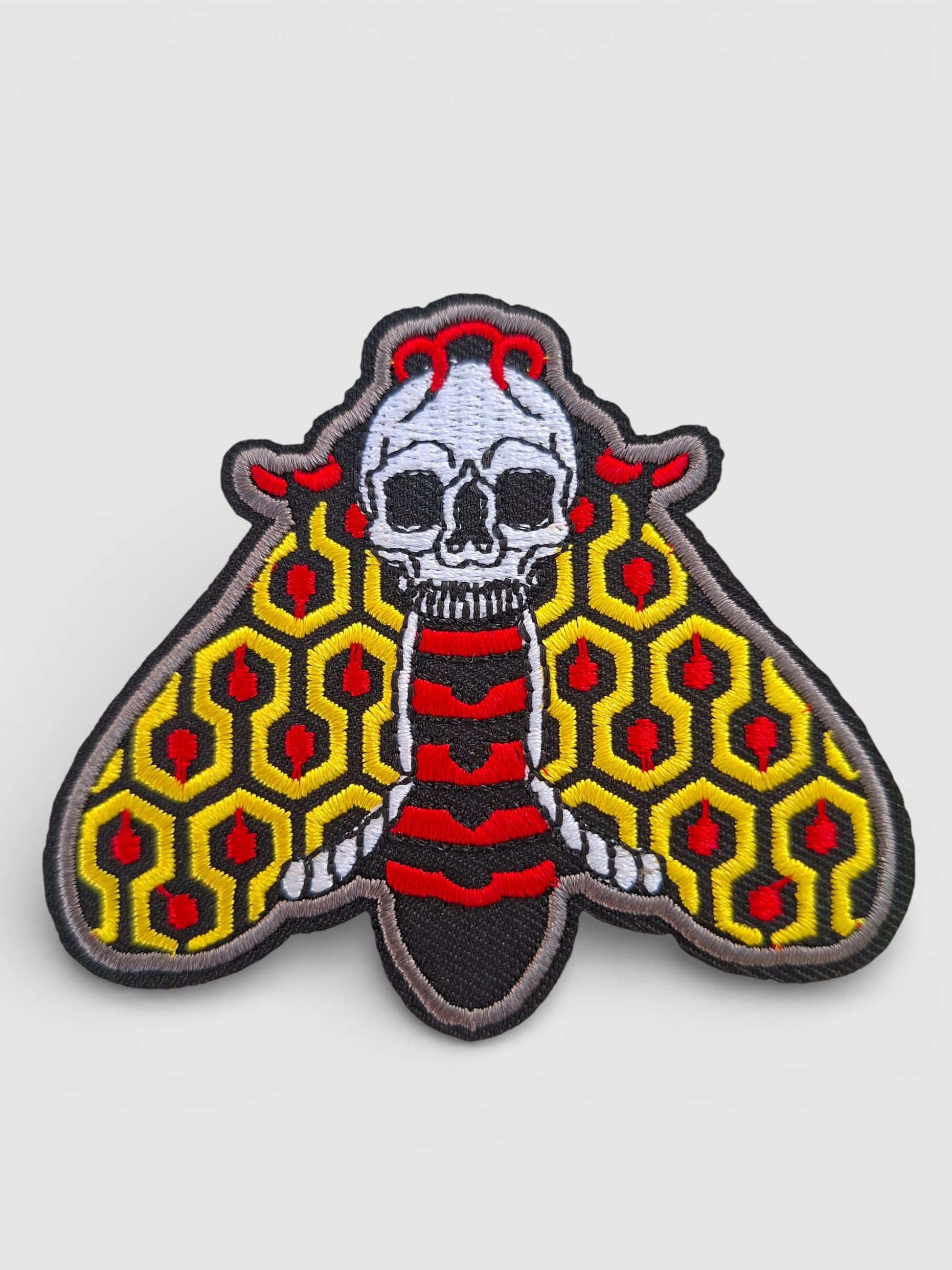 Parche premium bordado de polilla en colores vibrantes, inspirado en el estilo de tatuaje tradicional old school.