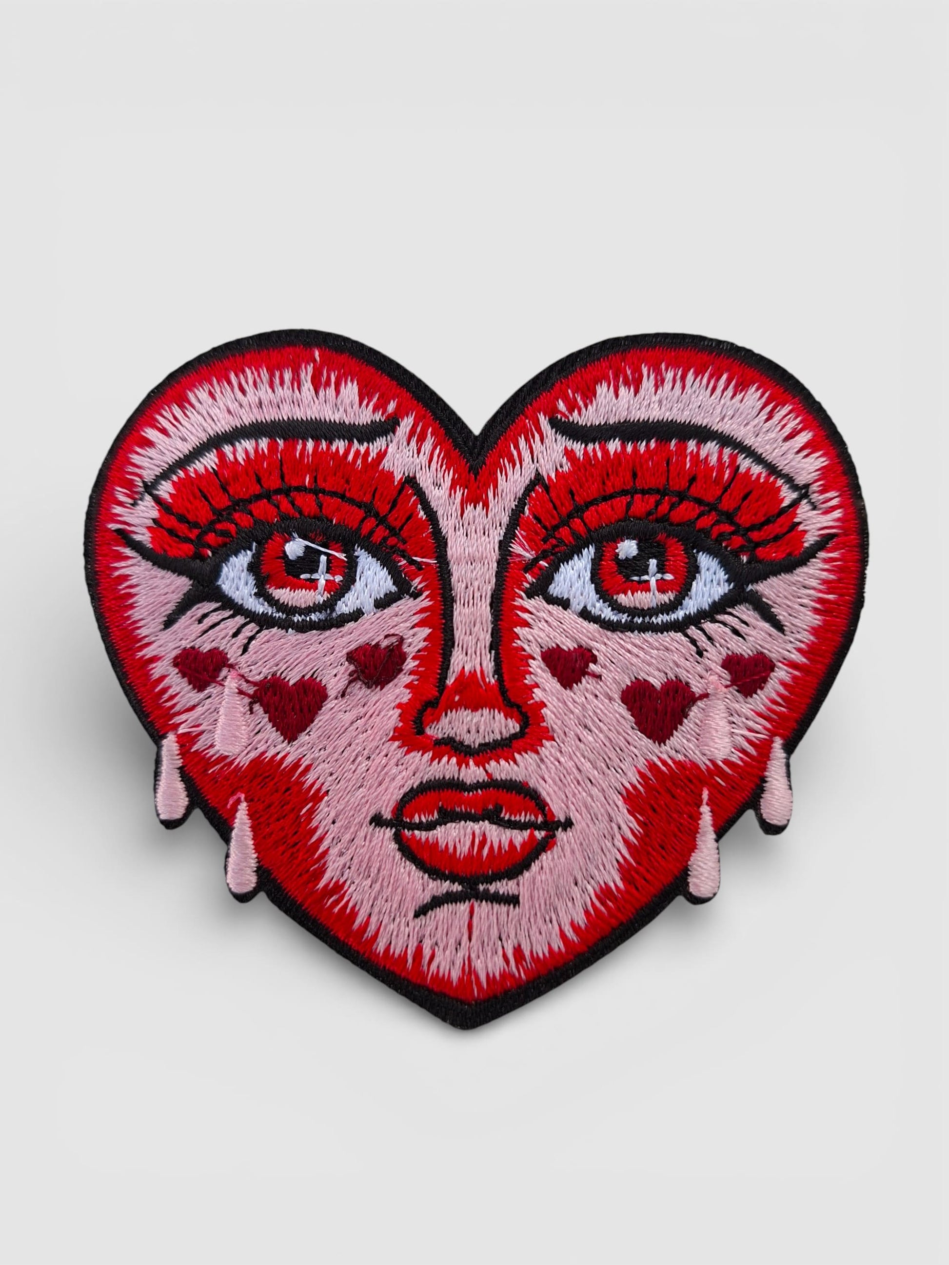 Detalle de parche bordado corazón llorando diseño tattoo tradicional old school