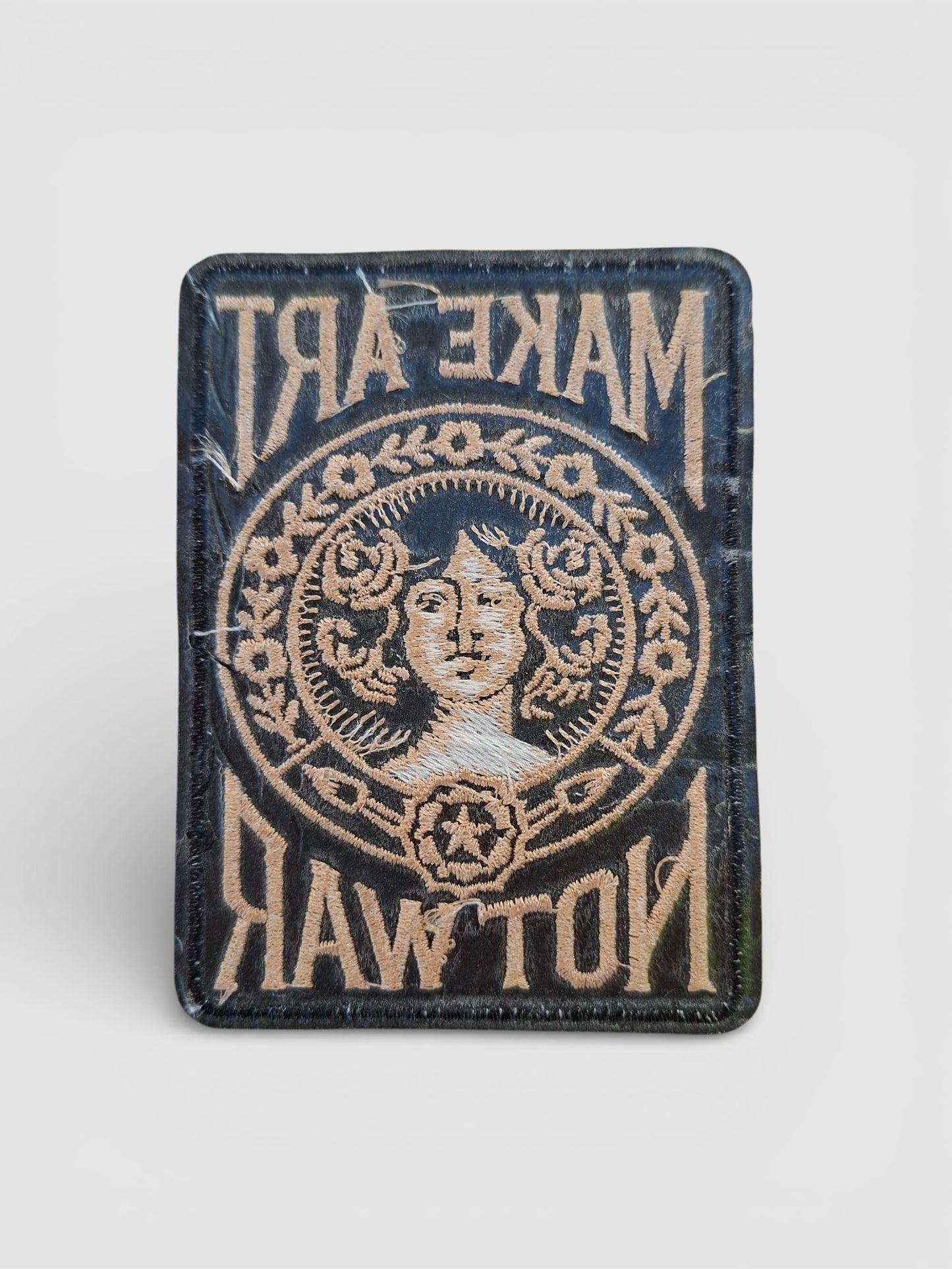 Parte trasera parche bordado estilo vintage con tipografía retro y motivos florales.