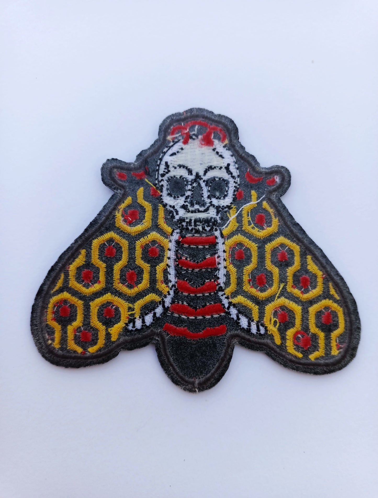 Parte trasera parche de tela con polilla detallada en tonos retro, ideal para chaquetas, mochilas o gorras.