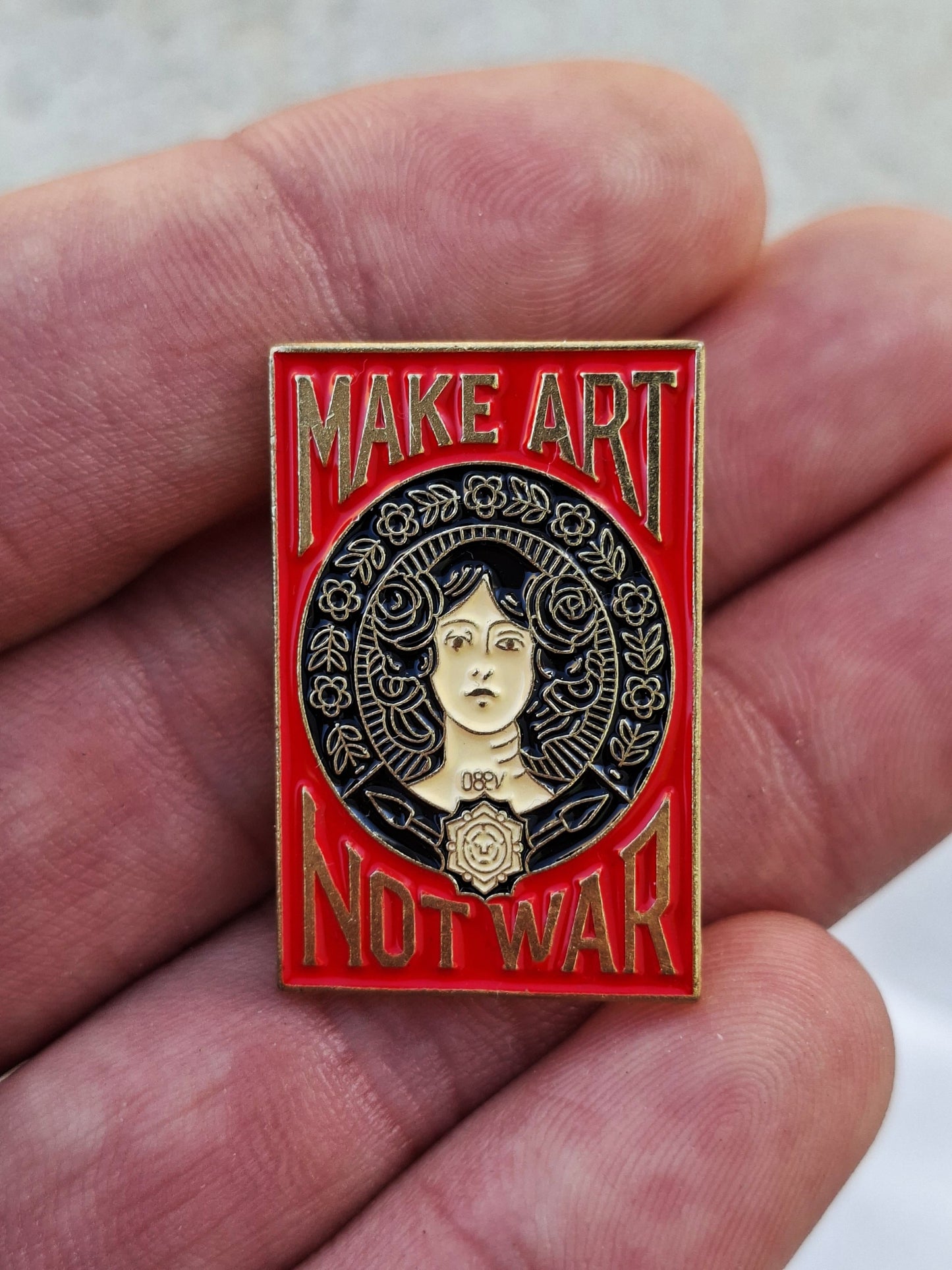 Pin estilo Old School – Haz Arte No Guerra, rojo y dorado.