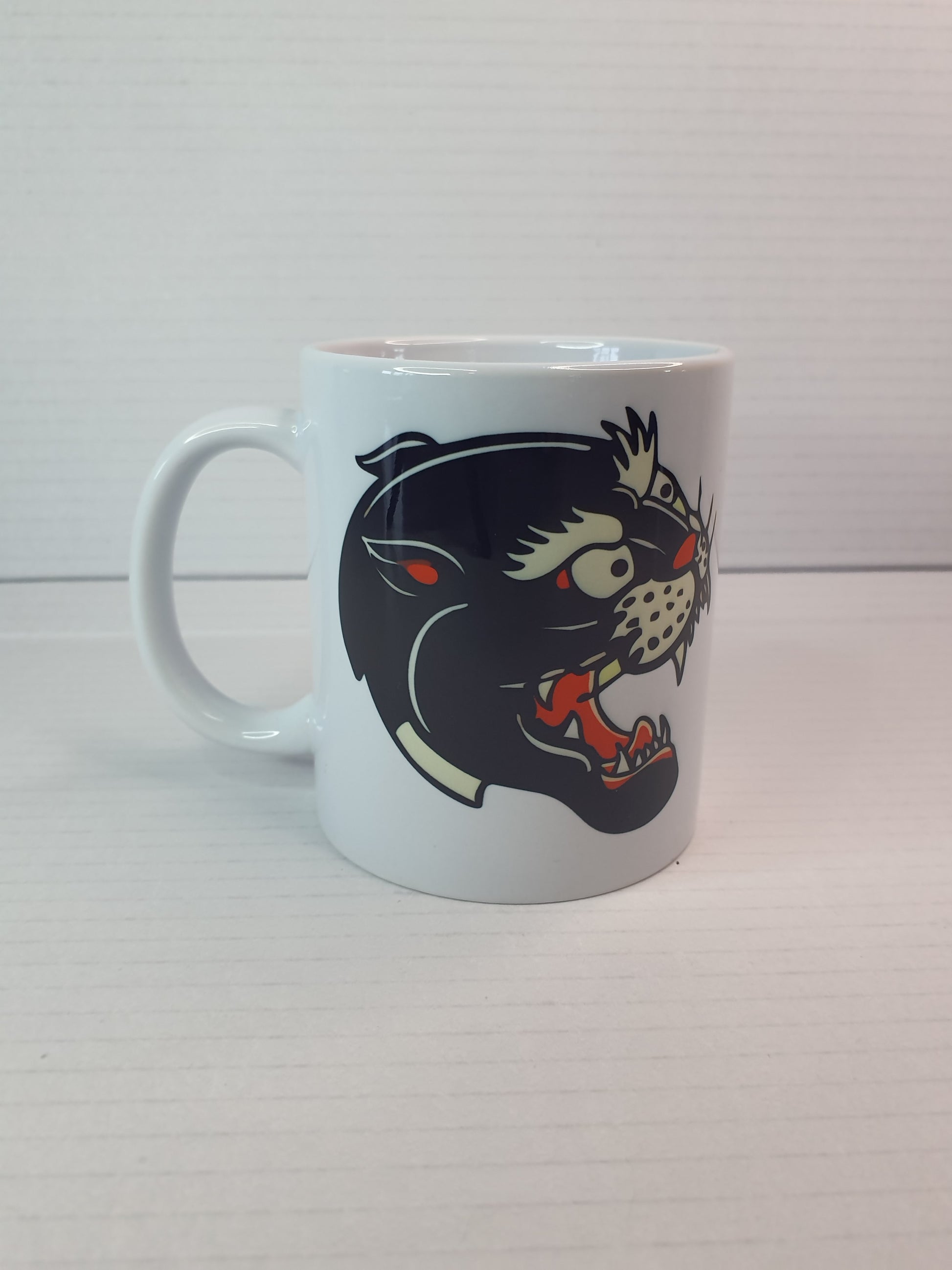 Taza con diseño de pantera old school, estilo tatuaje tradicional, ideal como regalo original para amantes del tattoo vintage.