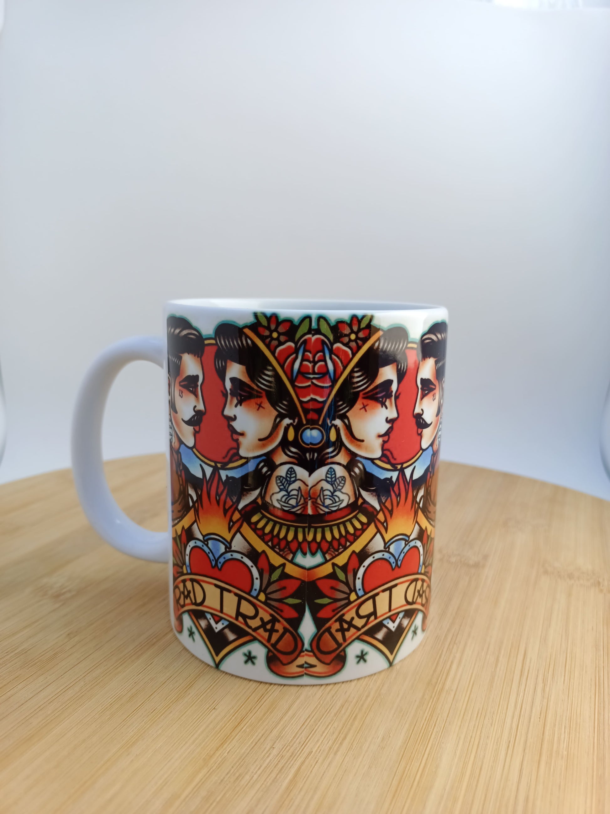 Taza de cerámica estilo tattoo old school con diseño tradicional de doble perfil, corazones y llamas