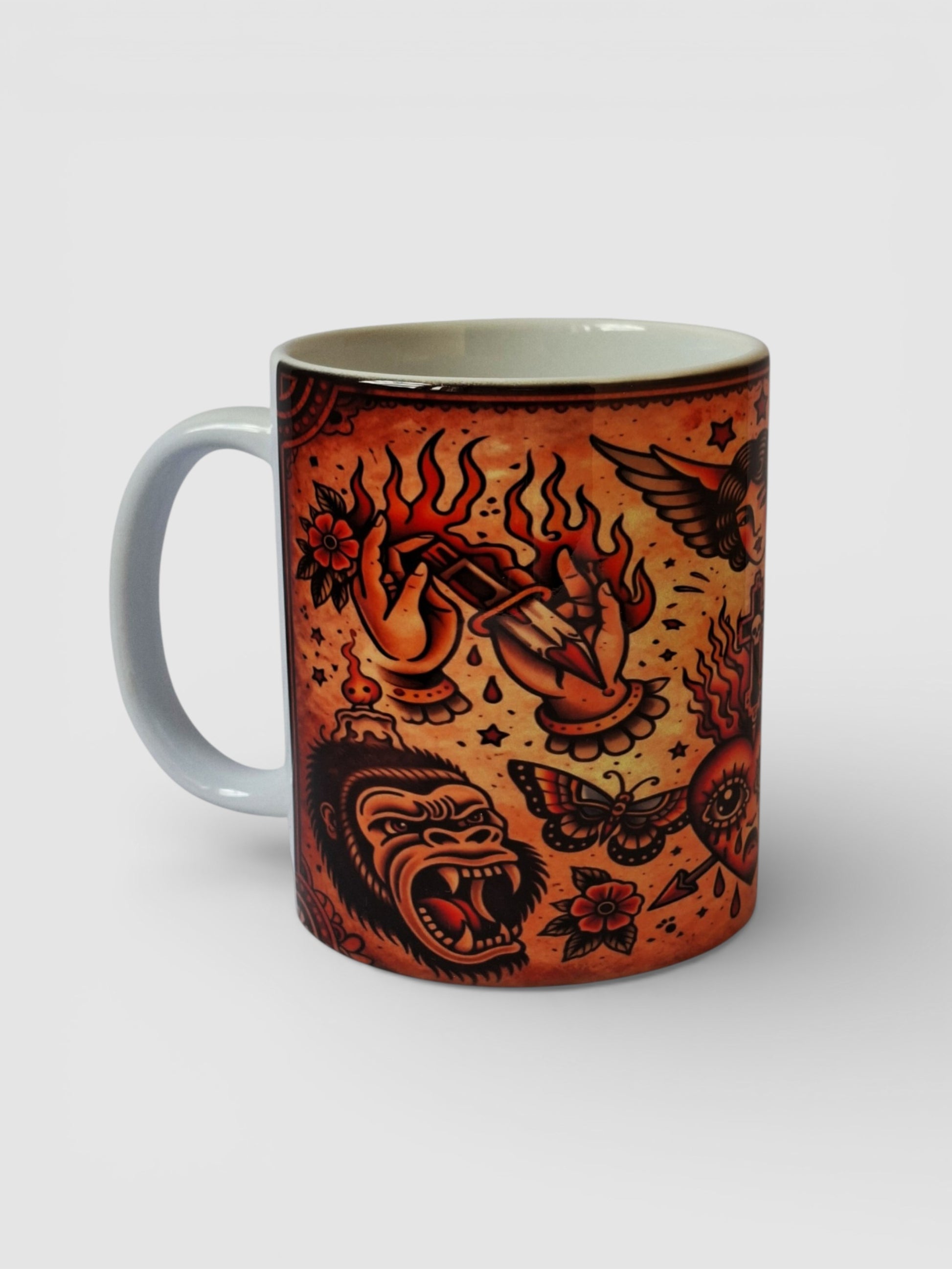 Taza estilo old school americana con ilustraciones clásicas de tatuaje en tonos rojizos.