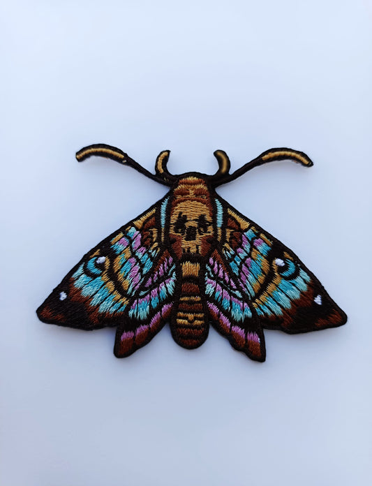 Parche bordado de mariposa con diseño inspirado en tatuaje. Colores vivos y líneas limpias.